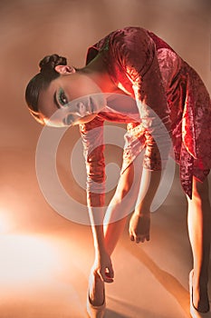 High Fashion model woman in colorful bright lights posing in studio,