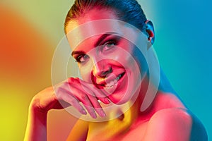 High Fashion model woman in colorful bright lights posing in studio