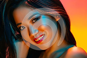 High Fashion model woman in colorful bright lights posing in studio