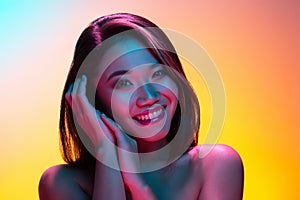 High Fashion model woman in colorful bright lights posing in studio