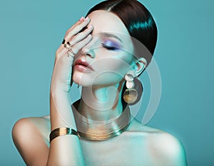 High Fashion model woman in colorful bright lights posing in studio.