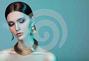 High Fashion model woman in colorful bright lights posing in studio.