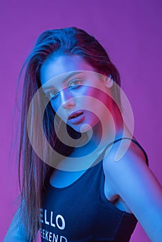 High Fashion model woman in colorful bright lights posing in studio, portrait of beautiful sexy girl