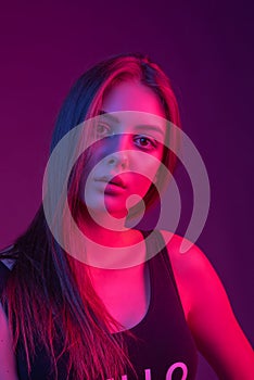 High Fashion model woman in colorful bright lights posing in studio, portrait of beautiful sexy girl