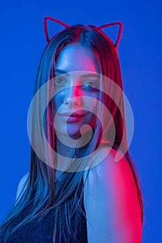 High Fashion model woman in colorful bright lights posing in studio, portrait of beautiful sexy girl with make-up