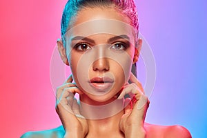 High Fashion model woman in colorful bright lights posing in studio