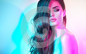 High Fashion model woman in colorful bright neon lights posing in studio, night club. Portrait of beautiful dancer girl in UV