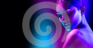 High Fashion model woman in colorful bright neon lights posing in studio, night club. Portrait of beautiful girl in UV