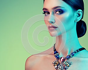 High Fashion model woman posing in studio. Portrait of beautiful sexy girl wearing jewelry with trendy make-up