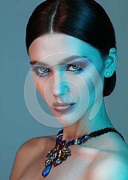 High Fashion model woman posing in studio. Portrait of beautiful sexy girl wearing jewelry with trendy make-up