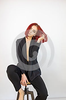 High fashion photo of a beautiful elegant young woman in black suit posing on white background