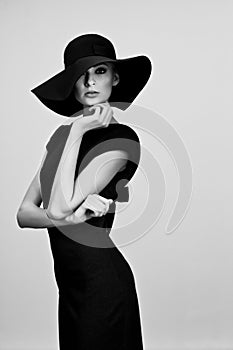 High fashion portrait of elegant woman in black and white hat an