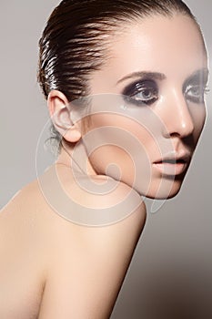 High fashion style. Model with dark gloss make-up, wet hairstyle