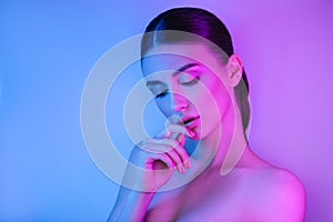 High Fashion woman in colorful bright neon uv blue and purple lights, posing in studio