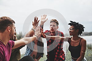 High five everyone. Group of people have picnic on the beach. Friends have fun at weekend time