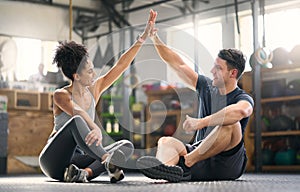 High five, motivation and fitness with a man and woman celebrating as a winner pair together in a gym. Team, success and