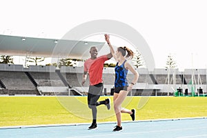 High five, sports and teamwork on outdoor track, celebrate and winners of running competition. Athletes, happy people