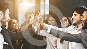 High-five for success. Diverse group of business colleagues in office photo