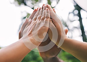 High fives of a diverse group of people. Closeup of multiethnic hands touching in the air. Group give high five as a