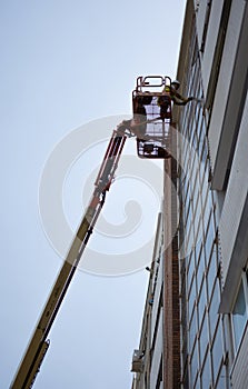 High-Flying Craftsmanship: Worker on Aerial Lift at Glass Tower