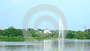 High fountain in the lake and speed boat passing