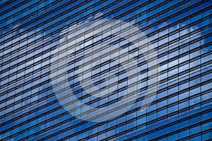 High glass skyscraper with reflection of blue sky and white clouds on the street of Singapore. Office windows background