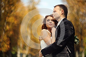 High hopes - wedding couple stands in an autumn park