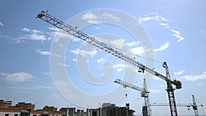 High industrial tower crane at construction site of new residential building.