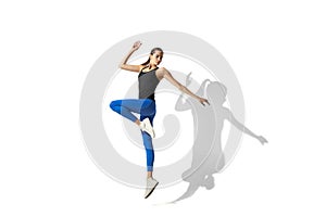 Beautiful young female athlete stretching on white studio background with shadows