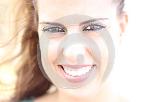 High key portrait of brunette young woman smiling on a sunny day