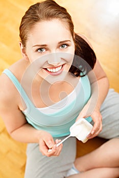 High key Portrait young caucasian woman eating yogurt at home