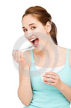 High key Portrait young caucasian woman eating yogurt isolated