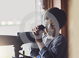 High key protrait of Kid boy looking through monocular, Active kid explorer bird watching in the animals station view point,