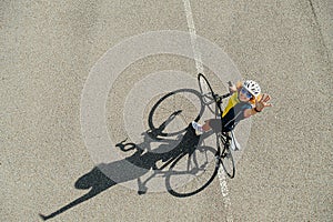 High longshot of a woman with curly hair in a helmet waving her hand at camera.