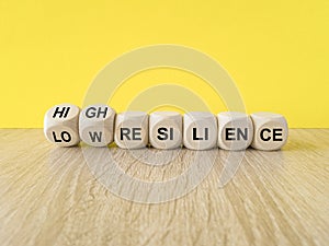 High or low resilience symbol. Turned wooden cubes and changes words \'low resilience\' to \'high resilience