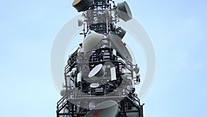 High metal tower with large and small satellite antennas