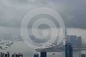 High modern buildings in fog and thick rain clouds of Hong Kong harbor from view point