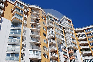 High Modern Yellow Urban Apartment Building under Blue sky.