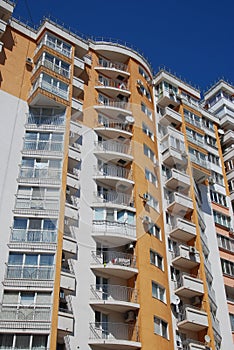 High Modern Yellow Urban Apartment Building under Blue sky.