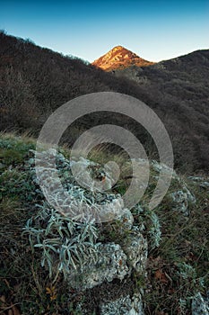 High mountain peak illuminated by the red light