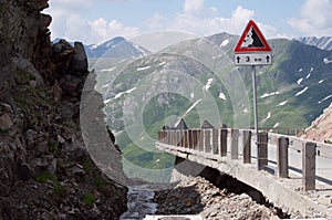 High mountain road the swiss alps with danger sign