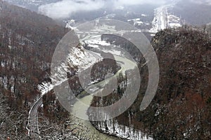 High-mountain, suspended rope bridge, which offers stunning views of the gorge, which runs a mountain river and a view of the vill