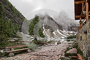 High mountain village - a stone path, a wooden fence in the middle of a coniferous forest