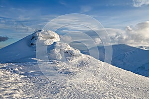 High mountains and blue sky. Mysterious fantastic rocks frozen with ice and snow of strange fairytales forms and structures.