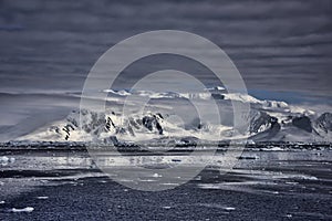 High mountains clad in cloud, reaching to the sea, Antarctica