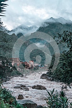 High mountains in the clouds and river in Aguas Calientes city