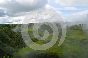 Beautiful landscape of mountains, lake, cloudy sky. Highlands surrounded by drifting clouds.