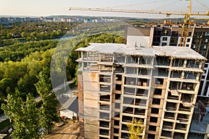 High multi storey residential apartment building under construction. Concrete and brick framing of high rise housing. Real estate