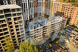 High multi storey residential apartment buildings under construction. Concrete and brick framing of high rise housing. Real estate