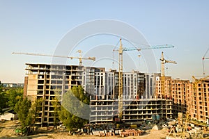 High multi storey residential apartment buildings under construction. Concrete and brick framing of high rise housing. Real estate